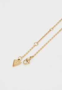 Collana in oro con un ciondolo triangolare. La catena presenta anelli ovali e un gancio a moschettone per una chiusura sicura.