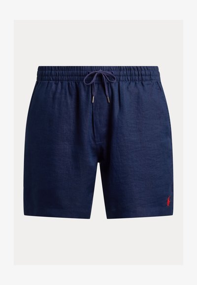 Μπλε σκούρο λιναράκι σορτς με ελαστική μέση, κορδόνι και μικρή κόκκινη λογότυπη λεπτομέρεια. Ομαλή υφή, σχέδιο μέχρι το γόνατο.