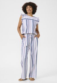 Completo a due pezzi a righe con top a maniche volants e pantaloni con coulisse. I colori includono bianco, blu e rosa. Tessuto leggero con una vestibilità rilassata.