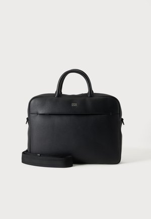 Serviette en cuir noir texturé avec poignées supérieures et bandoulière amovible, montrant un petit logo avant sur fond gris neutre.