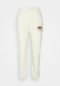 Crème-kleurige joggingbroek met een elastische tailleband, voorzien van een decoratief patroon van bloemen en kinderen op de linker bovenbeen.