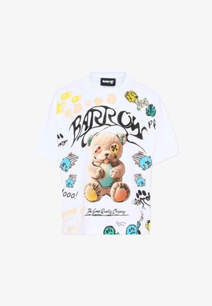 Camicia bianca a maniche corte con design colorati in stile graffiti, che presenta un orsetto logoro con un occhio a forma di bottone e vari elementi in stile cartone animato.