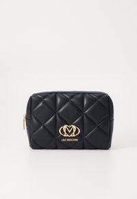 Navy quilted faux leather pouch with gold logo and hardware, featuring a rectangular shape and a zip closure.