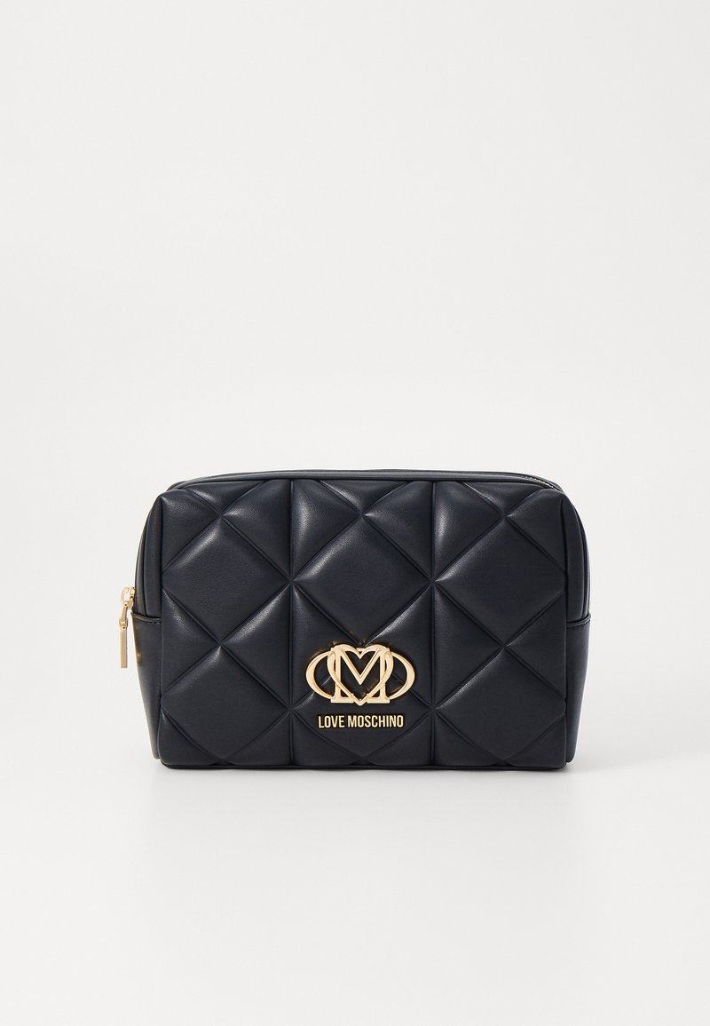 Navy quilted faux leather pouch with gold logo and hardware, featuring a rectangular shape and a zip closure.