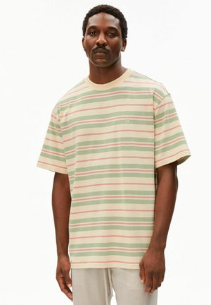 Man draagt een pastel gestreept shirt met korte mouwen met groene, roze en crèmekleurige horizontale strepen, staande tegen een witte achtergrond.