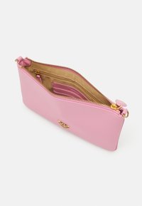 Clutch bag in pelle rosa con zip e dettagli in oro. L'interno presenta una fodera beige con più scomparti per l'organizzazione.