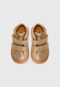 Gylne glitrende joggesko med to borrelåsremmer, avrundet tupp, beige gummisåle og polstret innersåle. Rent design, passende for barn.