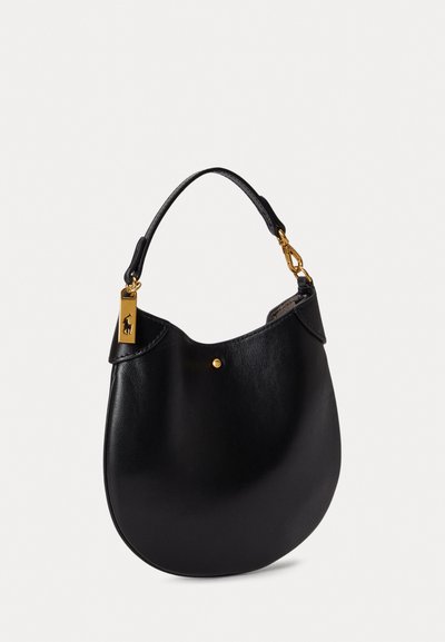 Μαύρη δερμάτινη τσάντα χειρός με στρογγυλή μορφή, κοντή λαβή, χρυσές μεταλλικές λεπτομέρειες και ένα μικρό λογότυπο. Λείος υφασμάς με μινιμαλιστικό σχέδιο.
