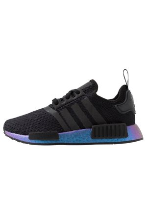 Sort strikket sneaker med sorte striber og en blå og lilla gradient sål, med en trækflap ved hælen og sort snørelukning.