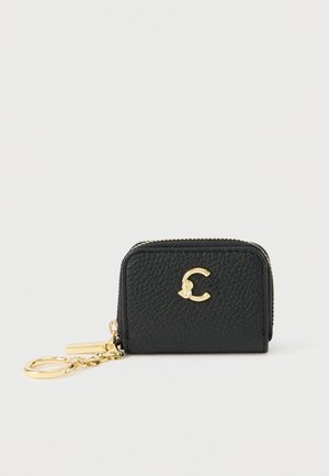 Sort lædernøglekop med en gylden lynlås. Har en struktureret overflade og et guld cirkulært logo på forsiden. Kompakt og rektangulært design.