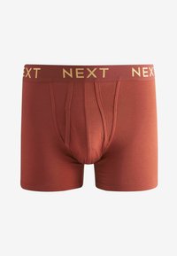 Boxers rouges en tissu extensible, avec un logo doré "NEXT" sur la ceinture et une poche contournée pour un meilleur maintien.