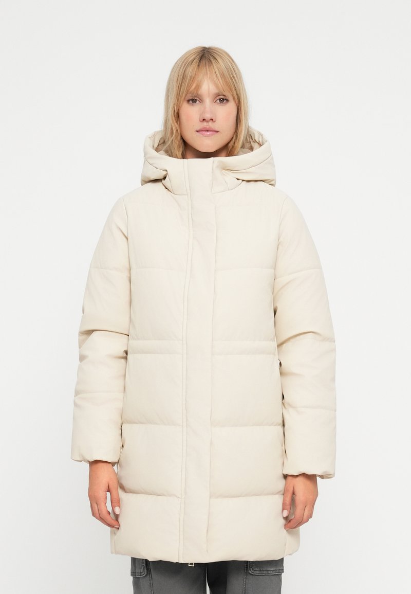 Beige polstret jakke med hætte, der har lynlås lukning og syede sektioner. Designet har en afslappet pasform og lange ærmer.