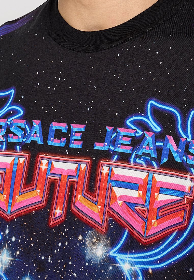 Camiseta gráfica negra con un fondo estrellado, con el texto en azul y rosa "SPACE JEANS FUTURE" en negrita y acentos neón.