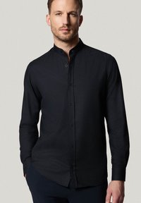 Czarna koszula z długim rękawem, z kołnierzykiem mandarynkowym, gładką teksturą, zapięciem na guziki i dopasowanym krojem. Minimalistyczny styl bez widocznych wzorów.