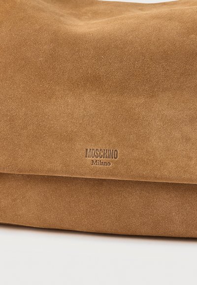 Μαλακή τσάντα από ταμπά σουέτ με διπλωτό καπάκι και χαραγμένο λογότυπο "Moschino Milano" στο κέντρο της μπροστινής πλευράς.