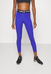 Leggings Nike Pro blu con una vita in logo nero, caratterizzati da una vestibilità aderente e tessuto morbido ed elastico per comfort e flessibilità.