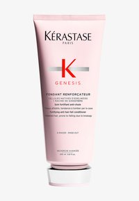 Kérastase Genesis conditioner in een roze tube met een witte basis, met een opvallende rode "K" en zilveren accenten, gelabeld als anti-haaruitval behandeling.
