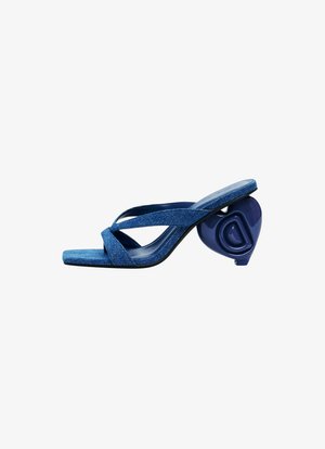 Sandales à glissière en denim bleu avec des brides croisées, bout carré et un talon en forme de cœur distinctif en bleu brillant. Semelle plate et tissu texturé.