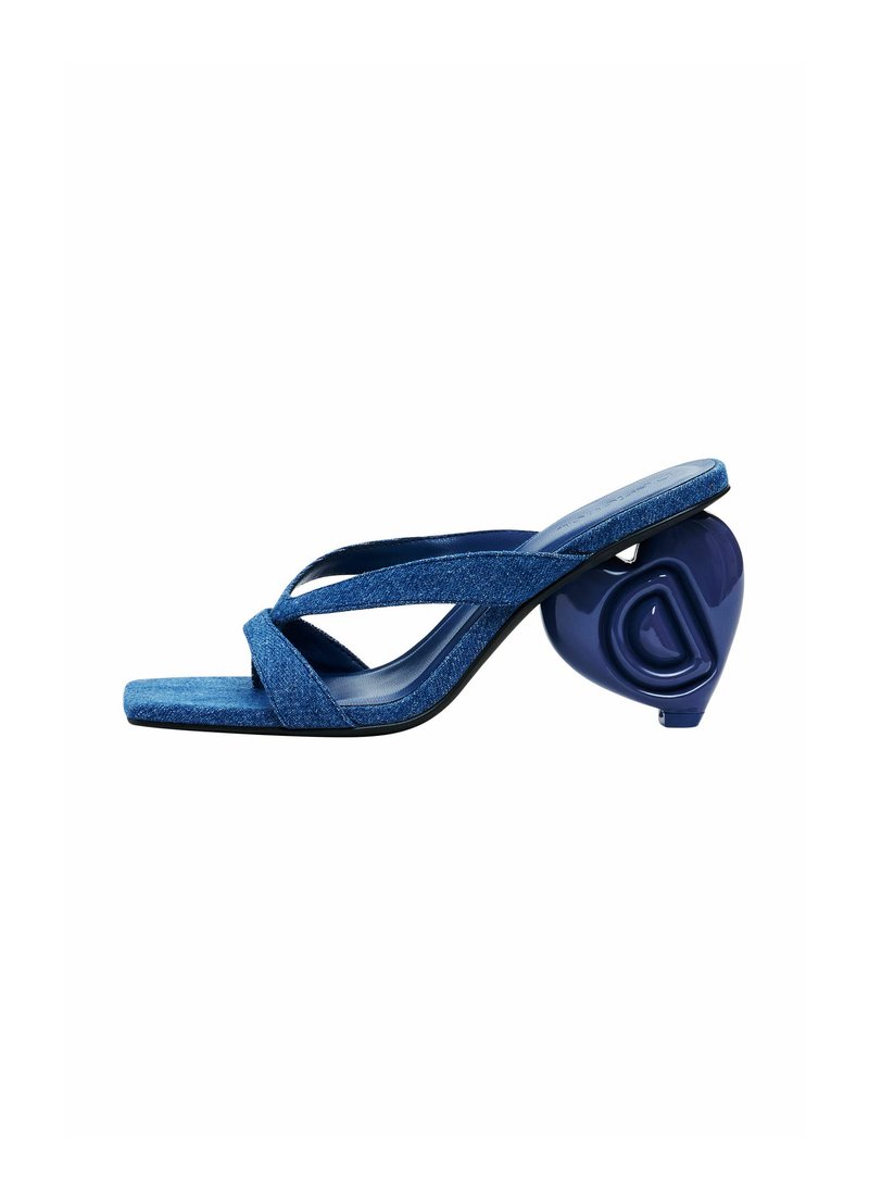 Blaue Denim-Slide-Sandalen mit Kreuzriemen, quadratischer Zehenpartie und einem markanten, herzförmigen Absatz in glänzendem Blau. Flache Sohle und strukturierter Stoff.