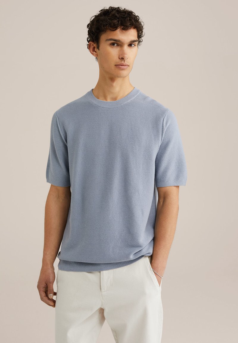 Light blue knit short-sleeve sweater with a round neckline, ribbed cuffs, and hem; smooth texture with a subtle horizontal pattern.