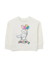 Sudadera de color crema con un dibujo de un conejo de dibujos animados sosteniendo globos coloridos y el texto "cinnamoroll" en una fuente divertida.