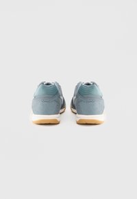 Footwear with a light blue mesh and suede upper, featuring a gum rubber sole, padded collar, and decorative stitching on the sides.