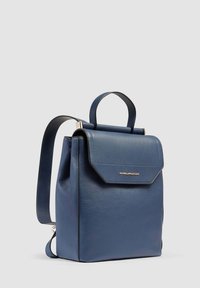 Zaino in pelle blu con un design strutturato, maniglia superiore, spallacci regolabili e chiusura a pattina con un accento del logo dorato.