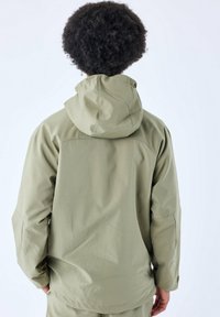 Giacca impermeabile verde oliva con cappuccio, caratterizzata da un tessuto testurizzato e una vestibilità rilassata. Dettagli visibili delle cuciture e tasche laterali.