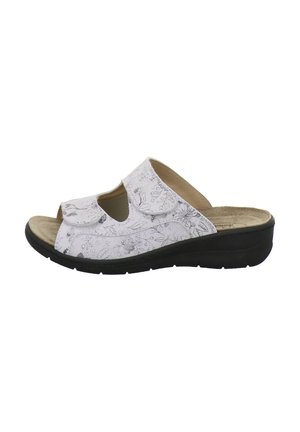 White slide sandal with black sole, floral pattern, two adjustable Velcro straps, and cushioned beige footbed.