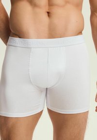 Białe bawełniane bokserki z wytłaczanym paskiem, dopasowany fason i gładka tekstura. Posiadają centralną kieszonkę i krótki krój nogawek.