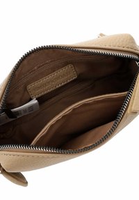 Beige leather handbag interior with a smooth texture. Features multiple compartments and a zipper closure with dark zipper teeth.