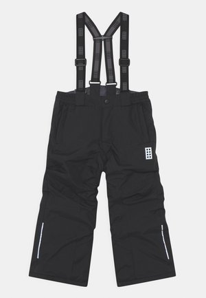 Pantalones impermeables negros para la nieve con tirantes ajustables, cintura elástica y detalles reflectantes. Incluyen un parche con el logo y piernas entalladas.