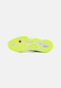 Suela de zapato deportivo con un diseño texturizado en un brillante color amarillo neón y acentos en azul, rojo y blanco. Patrón estriado para mayor tracción.