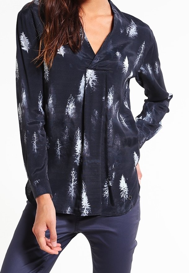 Chemise noire à manches longues avec un motif d'arbre pâle, col en V et texture lisse. Ourlet arrondi et détail de bouton sur le côté.