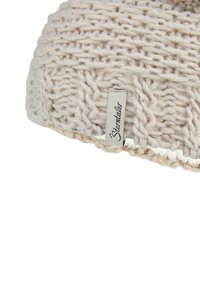 Knitted beanie in light beige with a textured pattern. Features a stitched white edge and a tag labeled "Sterntaler."