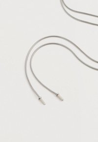 To sølvslanger med cylindrisk endehætter ligger på en hvid overflade, arrangeret i buede sløjfer.