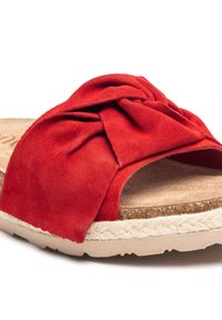 Sandal in suede rosso con design anteriore attorcigliato, suola in sughero e dettagli in juta intrecciata. Presenta punta aperta e forma arrotondata.