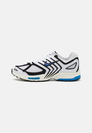 White athletic shoe with black accents, mesh panels, and blue details. Features a textured sole and sleek design lines.