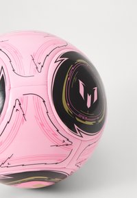 Ballon de football rose avec des accents noirs et des motifs de lignes dynamiques. Présente une surface lisse et brillante, ainsi qu'un logo proéminent sur un panneau.