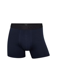 Marineblå boxershorts lavet af blødt stof. Har en sort elastik med præget logo, flade sømme og et tætsiddende design.