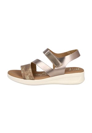 Sandalia metálica broncínea con dos amplias correas elásticas y una banda con estampado de serpiente texturizado. Plantilla acolchada sobre una suela baja en blanco.