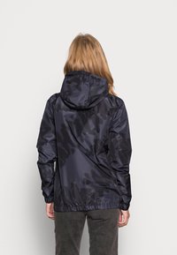 Mörk marinblå vattentät jacka med ett subtilt kamouflage-mönster, justerbar huva, elastiska ärmslut och ett indraget midjeband för en säker passform.