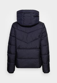 Mörk marinblå vadderad jacka med huva, chevronsömmar på ryggen, långa ärmar och en något kortad passform sedd bakifrån.