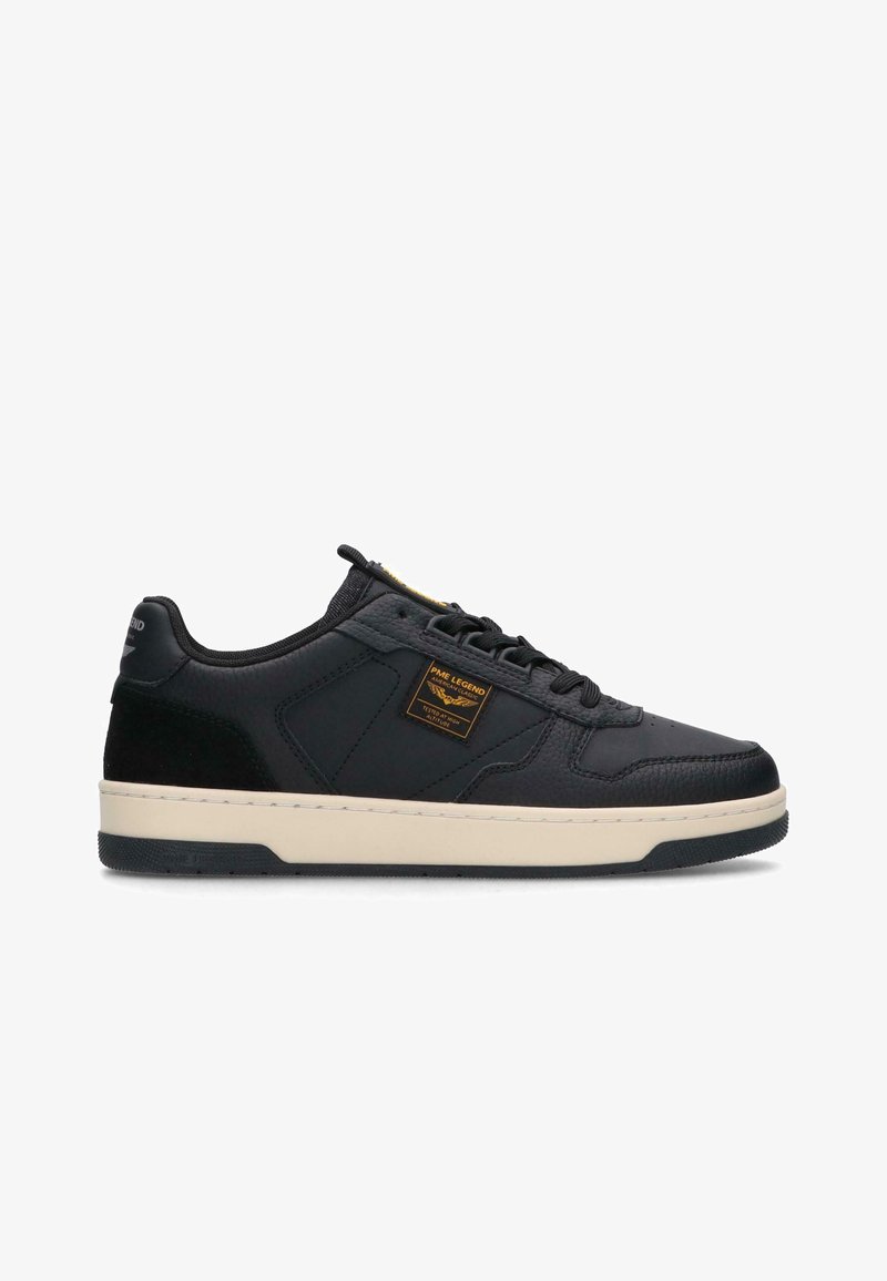 Sneaker noir bas avec semelle crème, lacets noirs et un petit patch jaune et noir sur le côté portant l'inscription PME Legend.