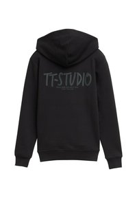 Sudadera negra con capucha ajustable. Presenta "TT-STUDIO" en letras negritas en la parte trasera, hecha de una tela suave y texturizada.