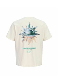 T-shirt écru avec un graphique en forme de soleil représentant une plage et des vagues de l'océan, et un texte turquoise « CAP MARTIN ROQUEBRUNE LE BEL ÉTÉ » dans le dos.