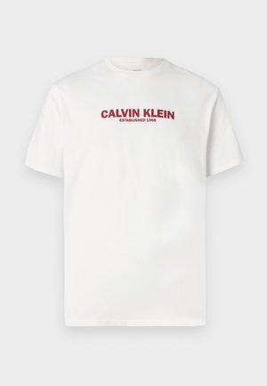 Bijela majica kratkih rukava s crvenim natpisom "CALVIN KLEIN ESTABLISHED 1968" centriranim na prsima.