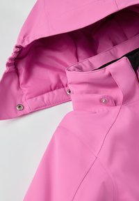 Vaaleanpunainen vedenpitävä takki, jossa on vuorattu huppu, napituksehdot ja tyylikäs muotoilu, pehmeä pinta ja kontrastivärinen sisus.