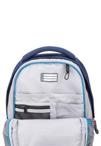 Grå ryggsäck med blå accenter har ett huvudfack, en zip-försedd framficka, en meshficka och ett handtag på toppen för bärande.