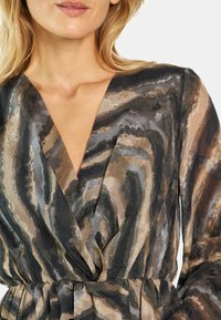 Gewebtes Kleid mit tiefem V-Ausschnitt, mehrfarbigen, wellenförmigen Streifen in Schwarz, Braun und Gold. Strukturiertes Material mit taillierter Passform und gefaltetem Rock.